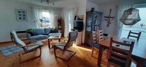 a living room with a couch and a table and chairs at FLOATING HOUSES - "schwimmende Ferienhäuser" - Haus 3 in Kröslin +27 photos