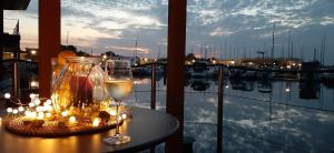 a table with a glass of wine and candles at FLOATING HOUSES - "schwimmende Ferienhäuser" - Haus 3 in Kröslin