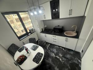a small kitchen with a table and a sink at Ama Residence in Brăila