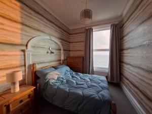 a bedroom with a bed and a large window at Brigg View Holiday Apartment in Filey