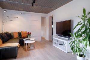 a living room with a couch and a flat screen tv at KS Apartment Modern & cozy flat 20 min from Bergen centre in Espeland