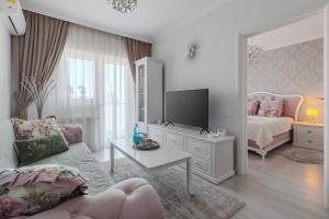 ein Wohnzimmer mit einem Bett und einem Fernseher in der Unterkunft ExceLLence BH Suite in Oradea + 10 Fotos