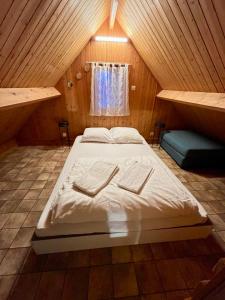 a large bed in a wooden room with a window at Chalet 5 personnes California Park in Cabourg +18 photos