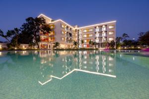 达曼Saavi Suites的建筑物前的一个大型游泳池