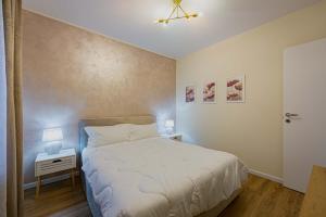 a small bedroom with a bed and a night stand with a nightstand at Bilocale Chic vicino al Teatro in Udine