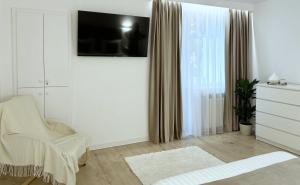 a white room with a chair and a window at Inga Oasis in Turda