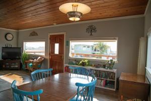 a dining room with a table and blue chairs at Views of Ocean and Iconic Morro Rock, Beach Cottage in Morro Bay