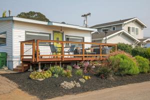 a house with a deck with two chairs on it at Views of Ocean and Iconic Morro Rock, Beach Cottage in Morro Bay