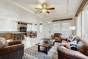 a living room with leather furniture and a ceiling fan at Water's Edge Escape in Chelan
