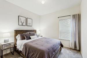 a white bedroom with a bed and a window at Water's Edge Escape in Chelan