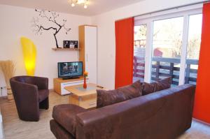 un salon avec un canapé et une télévision dans l'établissement Bungalow Timm, à Kellenhusen