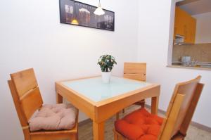 une table de salle à manger avec deux chaises et un vase avec des fleurs dans l'établissement Bungalow Timm, à Kellenhusen