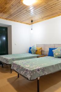 two beds in a room with blue pillows at Blue Ocean View in São Roque do Pico
