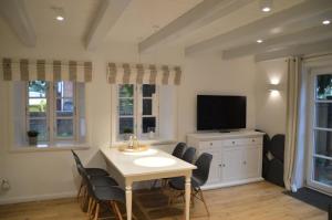 ein Esszimmer mit Tisch und Fernseher in der Unterkunft Haus Boldix Whg 1 Aruba in Boldixum