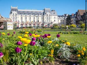 ein Blumenfeld vor einem großen Gebäude in der Unterkunft Appartement 2 pièces, 5 pers., parking, proche plage - FR-1-465-124 in Varaville