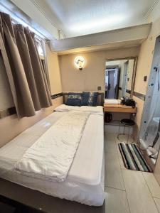 Una cama o camas en una habitación de 千城皇都賓館