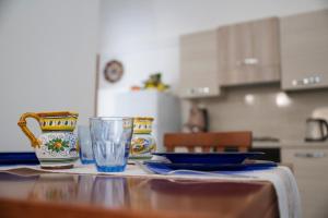 a table with two vases and a glass on it at M.A.M.A Home in Atrani