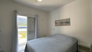 a bedroom with a bed and a large window at Casa aconchegante perto da Praia de Massaguacu in Massaguassu