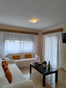 a living room with a white couch and a table at Perdika Resort in Perdika