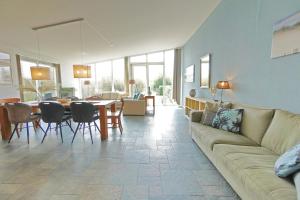 una sala de estar con un sofá y una mesa en Beachlife 9, en Callantsoog 19 fotos más
