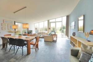 Una gran sala de estar con mesa y sillas. en Beachlife 9, en Callantsoog