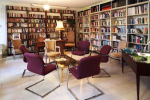 a library with purple chairs and bookshelves at Best Western Hotel Bellevue au Lac in Lugano