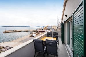 a balcony with two chairs and a table overlooking the water at Sea View Apartment Betina, Murter in Betina