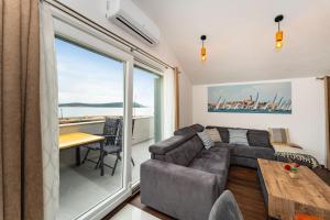 a living room with a couch and a table at Sea View Apartment Betina, Murter in Betina