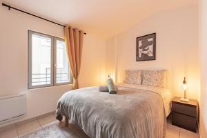 Un dormitorio con una cama y una ventana en Evasion chic au cœur de Béziers, en Béziers