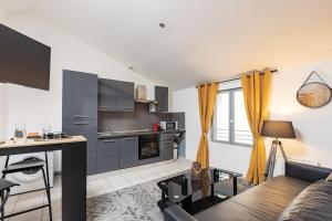 Una cocina y una sala de estar con un sofá y una mesa. en Evasion chic au cœur de Béziers, en Béziers