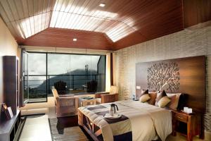 Un dormitorio con una cama grande y una ventana grande. en Ibex Resorts, Valparai Tale Rock, en Vālpārai