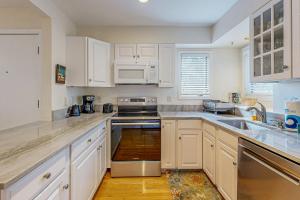 a kitchen with white cabinets and a stove top oven at Parkside 4518 in Kiawah Island