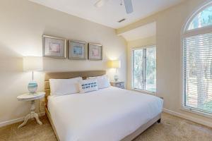 a bedroom with a white bed and two windows at Parkside 4518 in Kiawah Island +9 photos