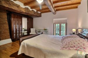 a bedroom with a large bed in a room with wooden ceilings at La loge du bourg in Lanrigan +13 photos