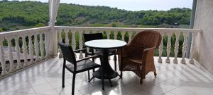 a table and chairs on a balcony with a view at Apartments Elena & Damir in Vis