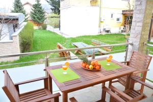 uma mesa de madeira com uma tigela de fruta na varanda em Apartment Mirela em Sarajevo