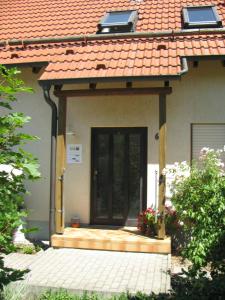 a house with a black door and a porch at Ferienwohnung Gelhausen in Herbsleben