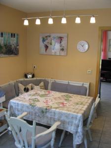 a dining room with a table and a clock on the wall at Ferienwohnung Gelhausen in Herbsleben +12 photos