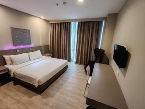 八打灵再也QQQ hotel type room Empire Damansara的配有床和电视的酒店房间