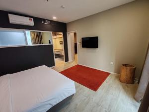 八打灵再也QQQ hotel type room Empire Damansara的卧室里有一张白色的床和一台平板电视