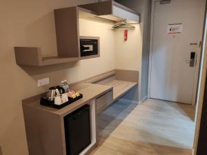 八打灵再也QQQ hotel type room Empire Damansara的一间带柜台的小厨房和一台电视
