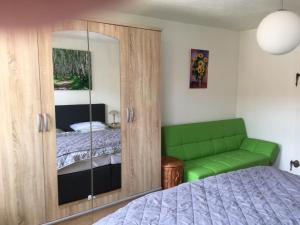 a bedroom with a green cabinet and a bed at frühsonnige Innenstadt-Vollkomfort-Wohnung in Zittau