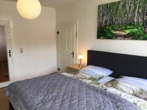 a bedroom with a bed and a painting on the wall at frühsonnige Innenstadt-Vollkomfort-Wohnung in Zittau
