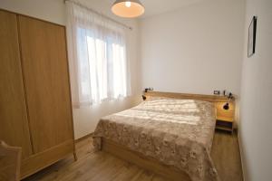 a small bedroom with a bed and a window at Dommu Livia in Lotzorai