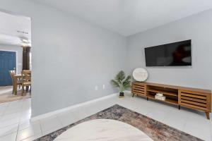 a living room with a flat screen tv on a white wall at Sunset Getaway Spacious Retreat Near Beaches & Local Attractions in Gulfport