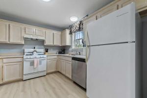 a kitchen with white appliances and a white refrigerator at Sunset Getaway Spacious Retreat Near Beaches & Local Attractions in Gulfport