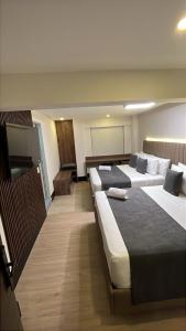 ボゴタにあるHotel Continental ByHoursの部屋にベッドが3つあるホテルの部屋