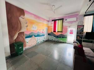 una habitación con un mural de una mujer en la pared en Vedartha Trails, en Rishīkesh
