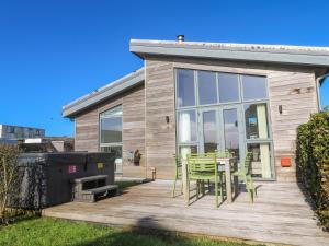 a house with a deck with a table and chairs at Una, Lodge 77 in St Ives