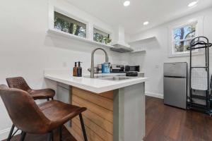 a kitchen with a sink and a counter with two chairs at Coastal Cabana Studio - Close to beach and Mississippi City in Gulfport +3 photos
